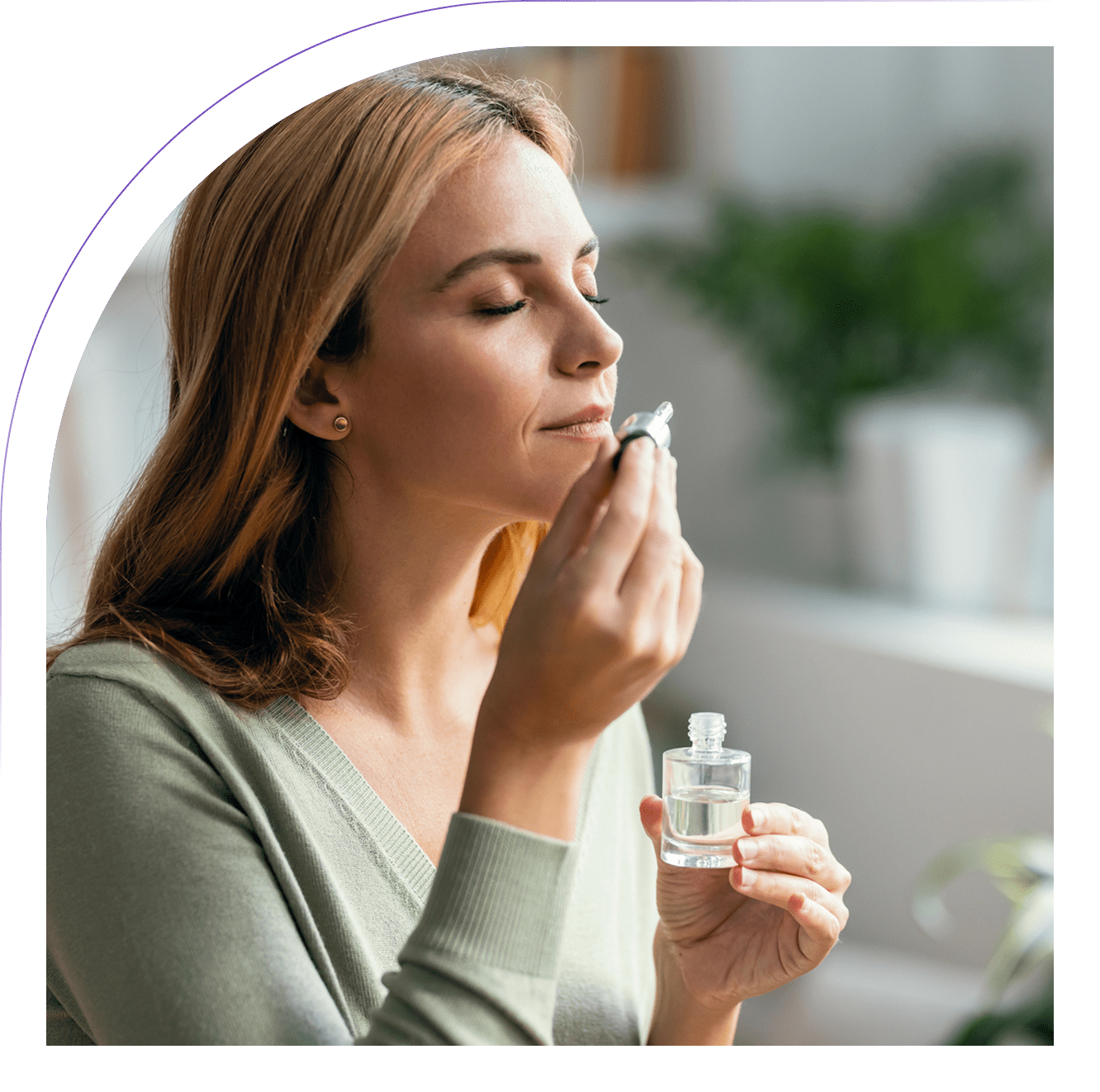Woman enjoying aroma from essential oil bottle. Woman enjoying aroma from essential oil bottle.